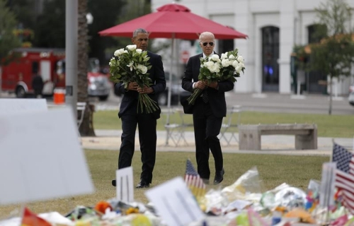U.S. President Obama and Vice President Biden carry flowers at makeshift memorial for shooting victims in Orlando, Florida